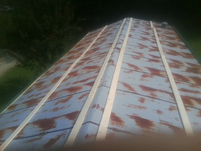 Rusted metal roof panels with new wood purlins before replacement — Storm Damage Roof Repair in Shirley by Roofing Brothers